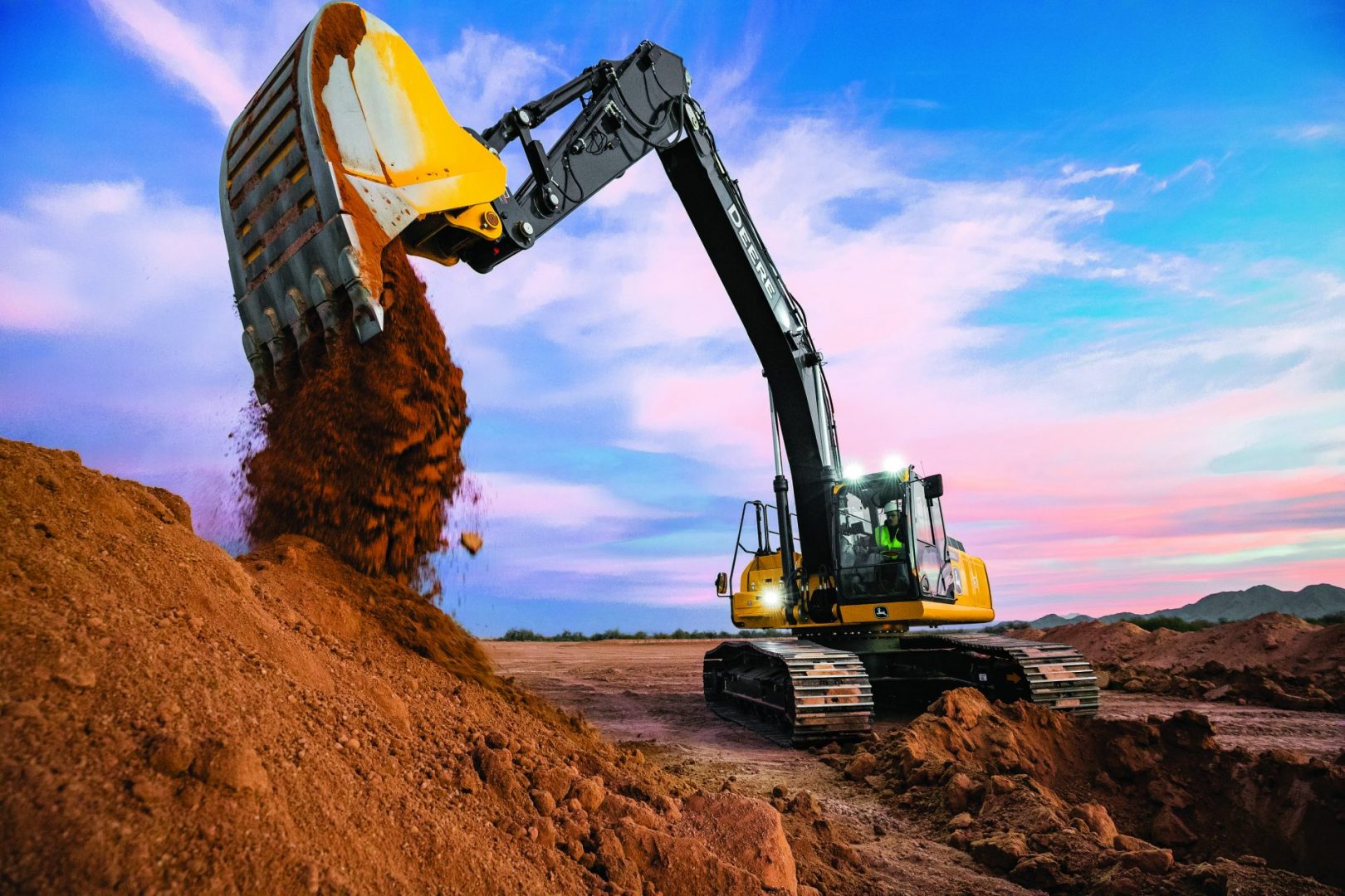 John Deere excavator dumps clay from its bucket, an excavator that is available through Fernandez's dealers.