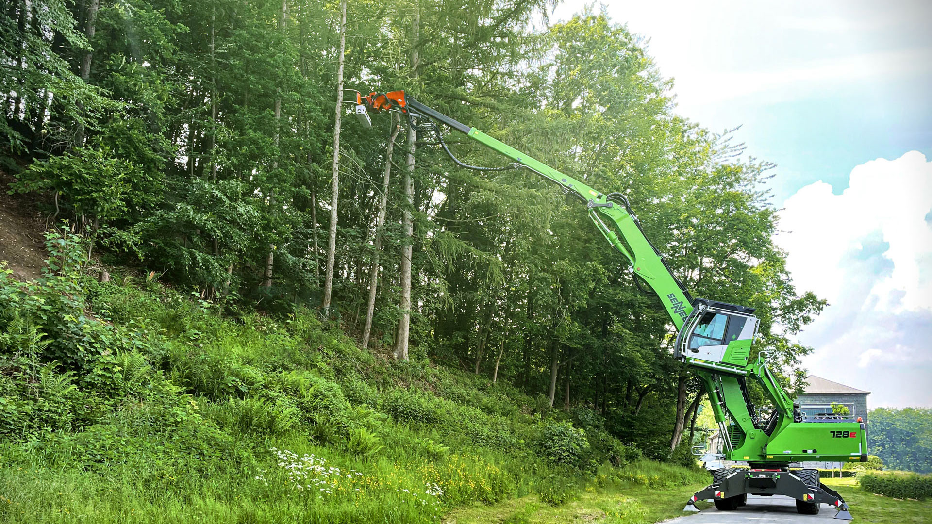 SENNEBOGEN's new 728 E reaches up, towards a tree, with its cab raised for better sightlines.
