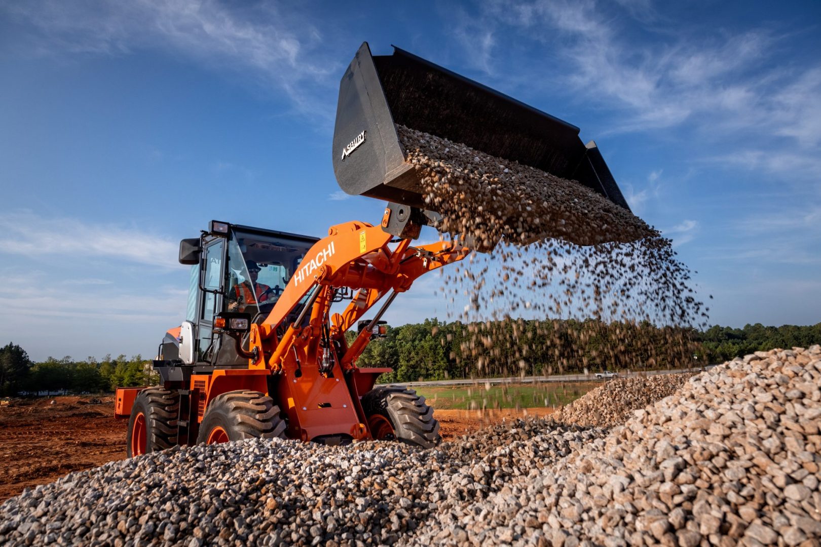 Hitachi ZW100-6 wheel loader dumping a bucket of gravel.