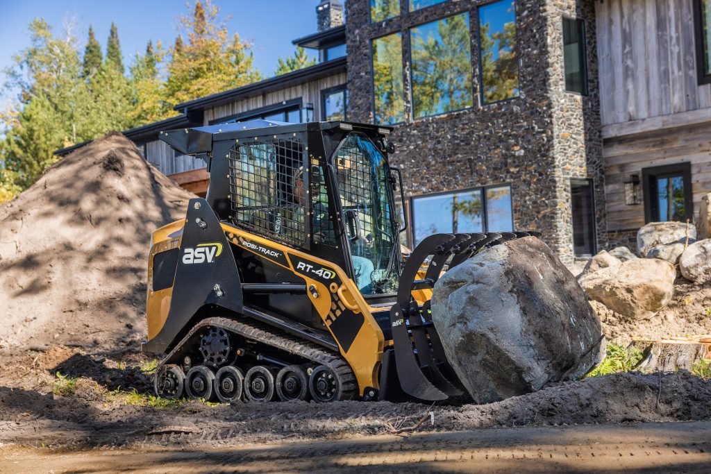 ASV RT-40 on a job site moving a large rock.