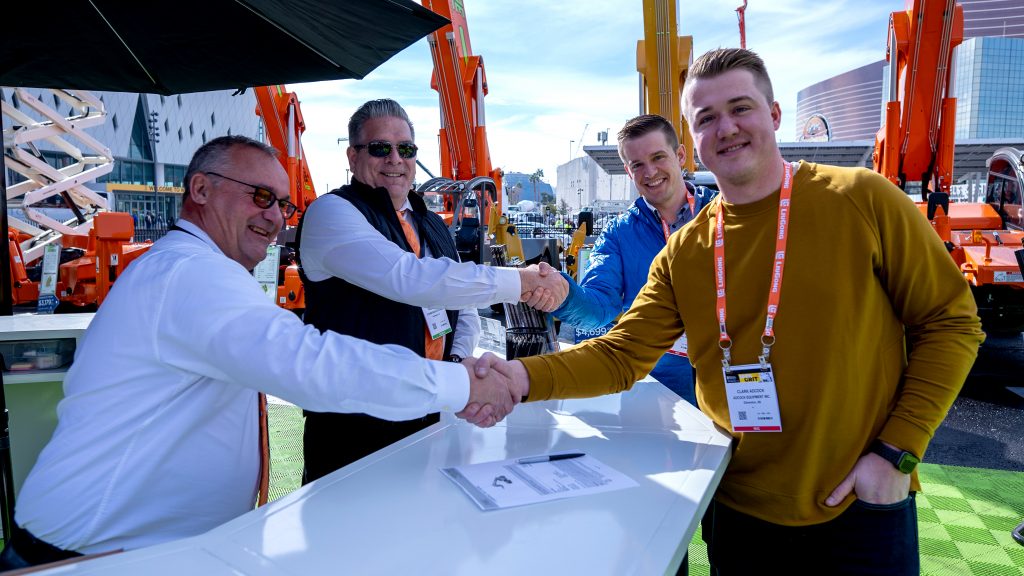 Adcock representatives shake hands on a deal to purchase an Xtreme XR7038.