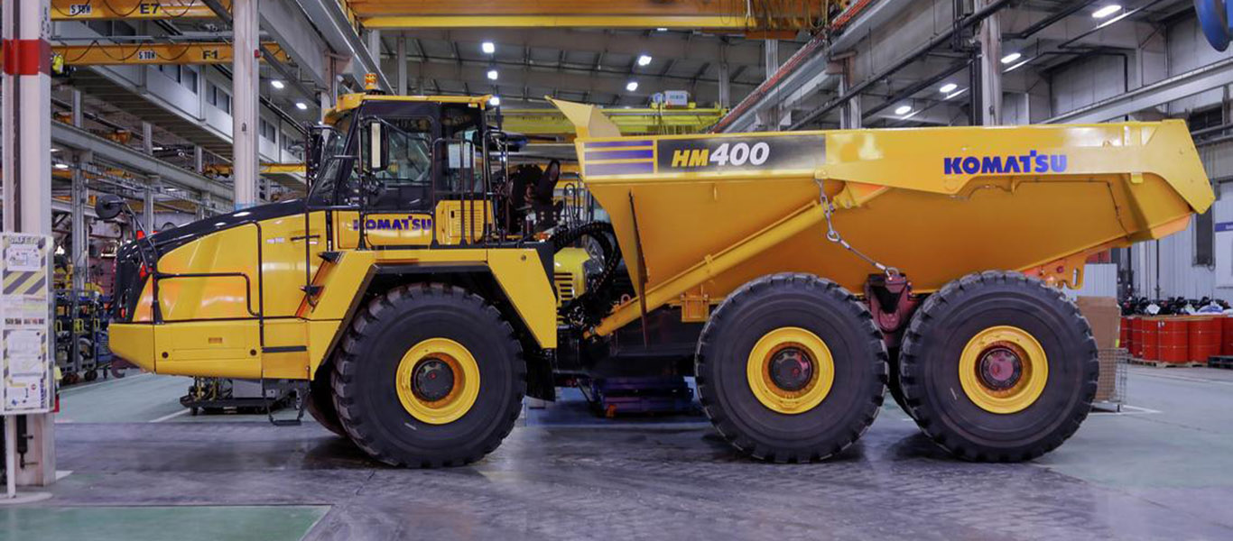 A komatsu HM400-5 articulated haul truck is parked in a facility