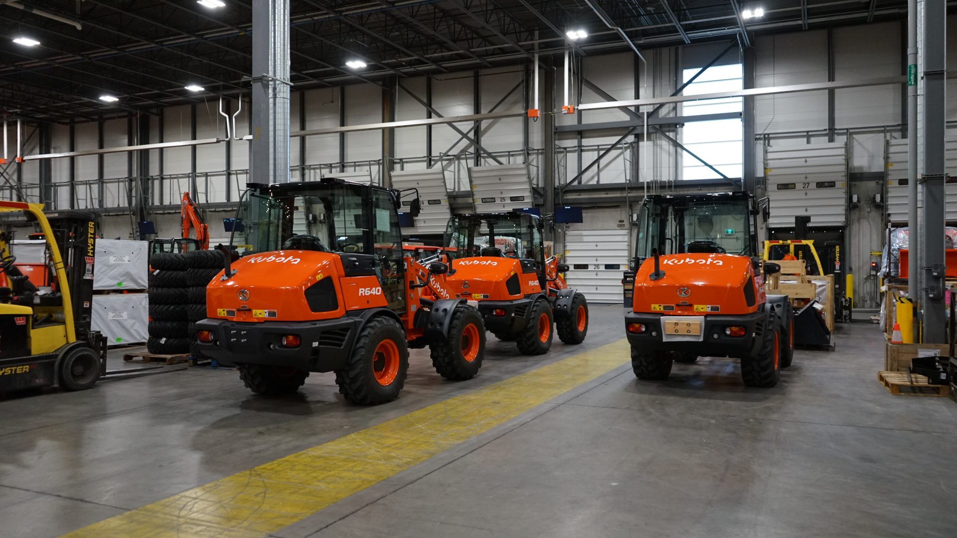 Kubota machines sit parked in a warehouse