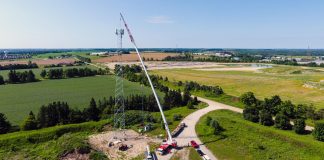 A link-belt crane builds a cell phone tower alongside a dirt road