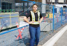 Laura Hutt, founder of Ruud Gear, stands in front of a construction site.